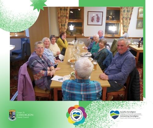 A group of elderly people sitting by a table having food